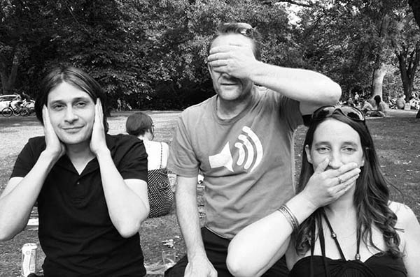 Three people in the park doing 3 Wise Monkeys