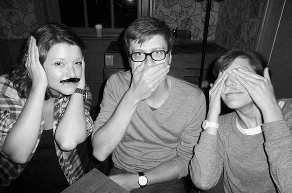 Three people with fake moustaches doing 3 Wise Monkeys