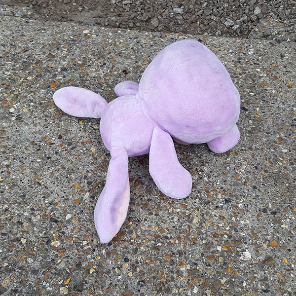 Face down pink bunny cuddly toy lying in the road