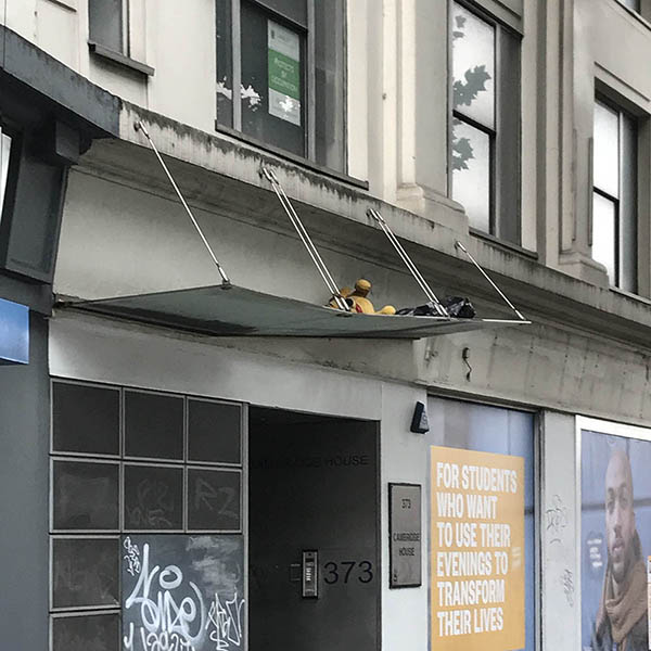 Abandoned, unwanted, unloved, cuddly toy - Winnie the Pooh teddybear, thrown onto on a building awning