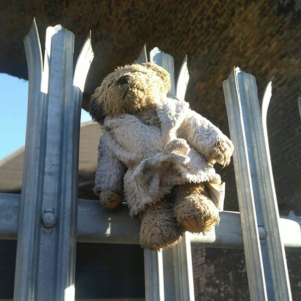 Teddy in a dressing gown hung on railings
