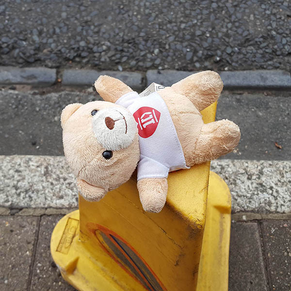 Abandoned, unwanted, unloved, cuddly toy - small teddybear wearing a 1D (One Direction) tshirt on top of a traffic cone at the curbside