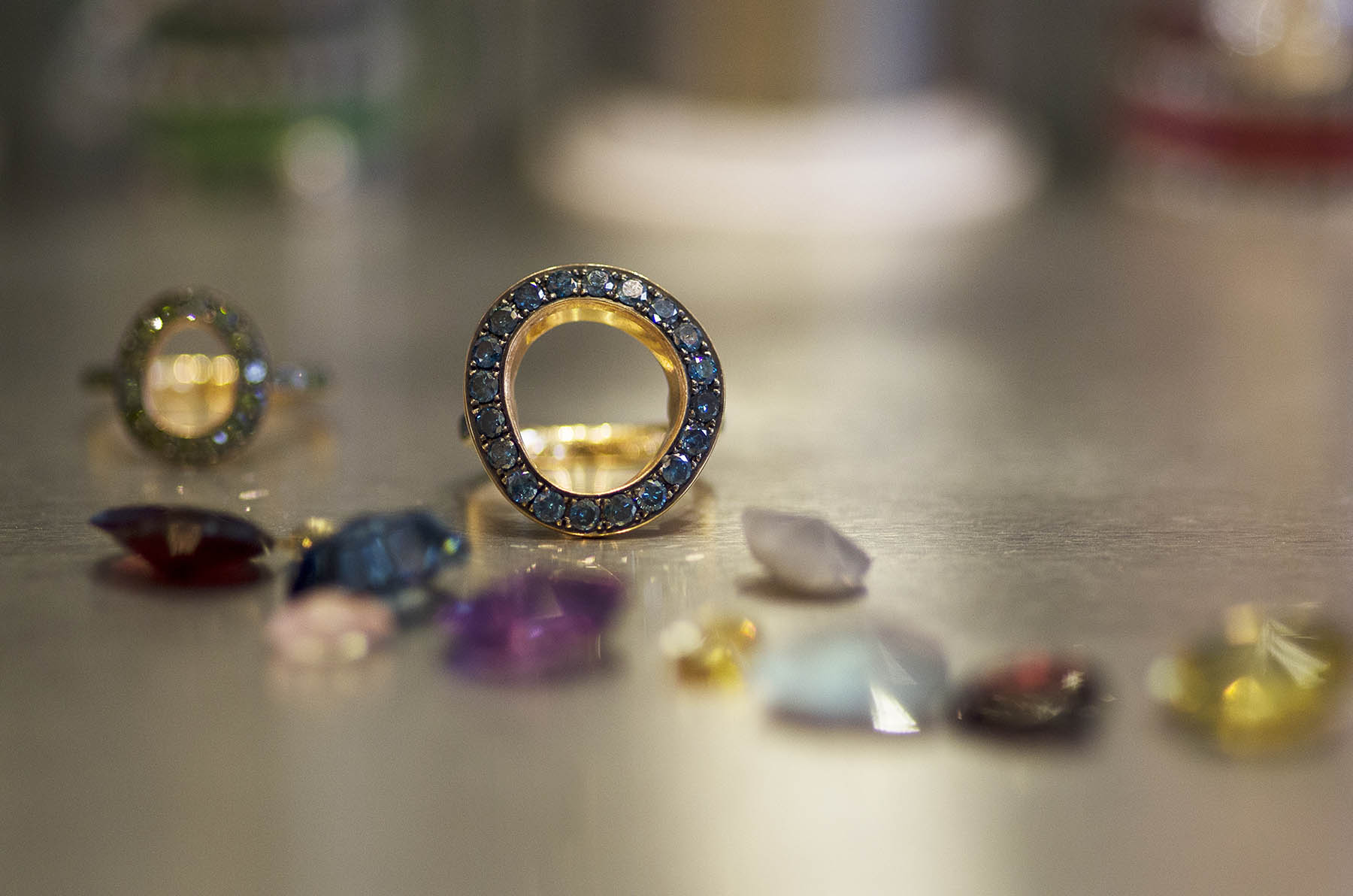 Annoushka Milestones Exhibition display cabinet - Dusty Diamond ring outer surrounded by assorted central gemstones