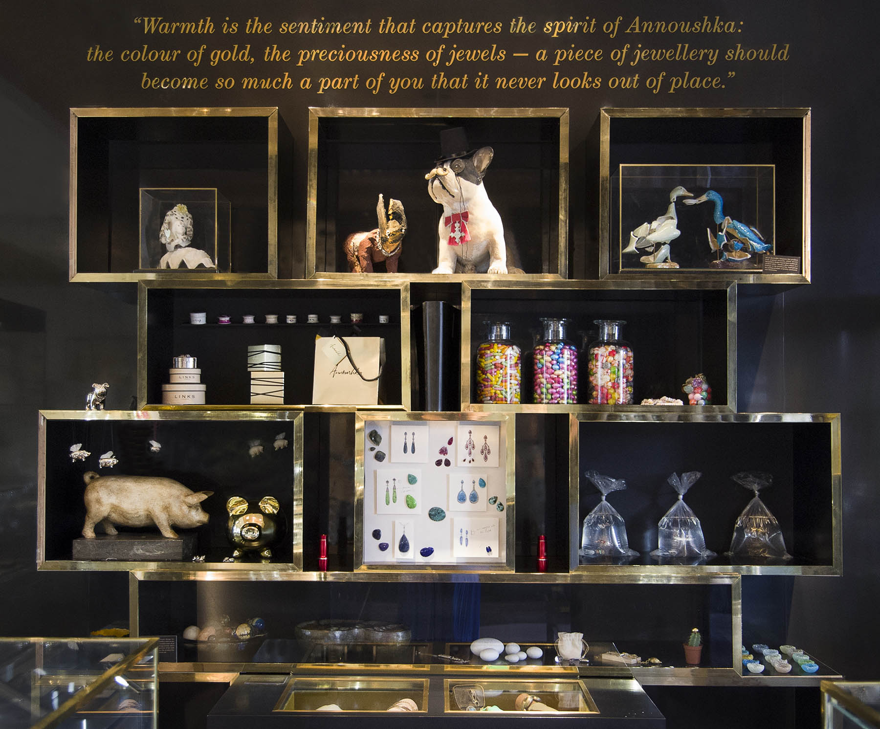 Annoushka Milestones Exhibition display cabinets with plastic dogs, ceramic ducks, jewellery packaging, wooden pig, gemstones