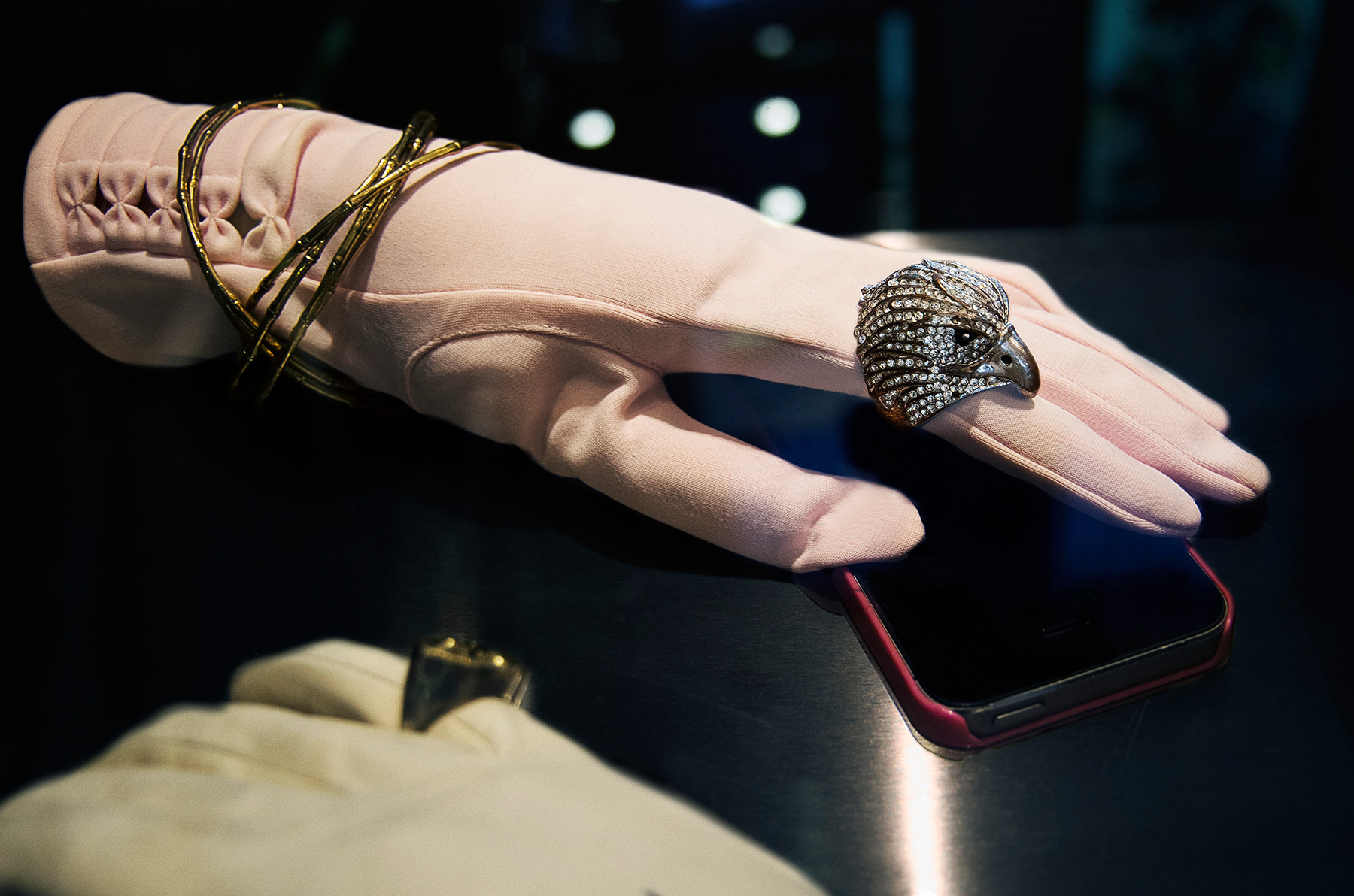 Annoushka Milestones Exhibition display cabinet - Jewellery worn on gloved mannequin hand with mobile phone