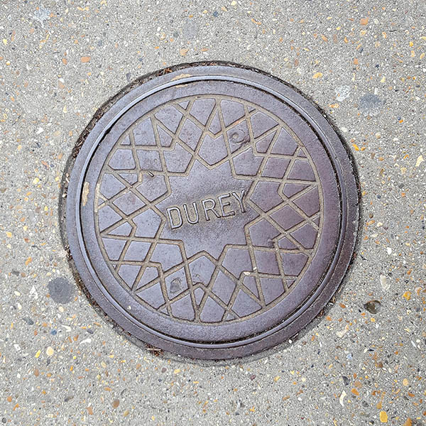 Manhole Cover, London - Cast iron with criss cross star pattern and Durey inscribed in the centre