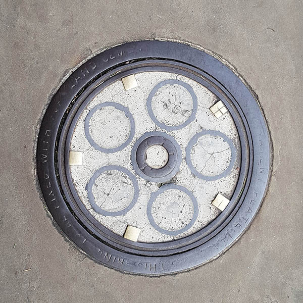Manhole Cover, London - Cast iron circles in concrete