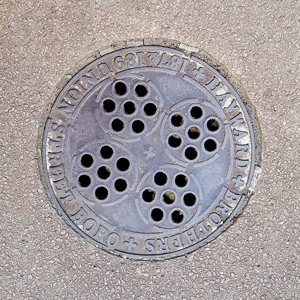 Manhole Cover, London - Cast iron with four circles of seven holes and outer text