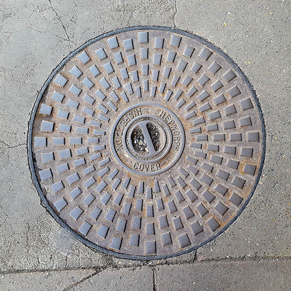 Manhole cover, London - Cast iron raised circular grid pattern