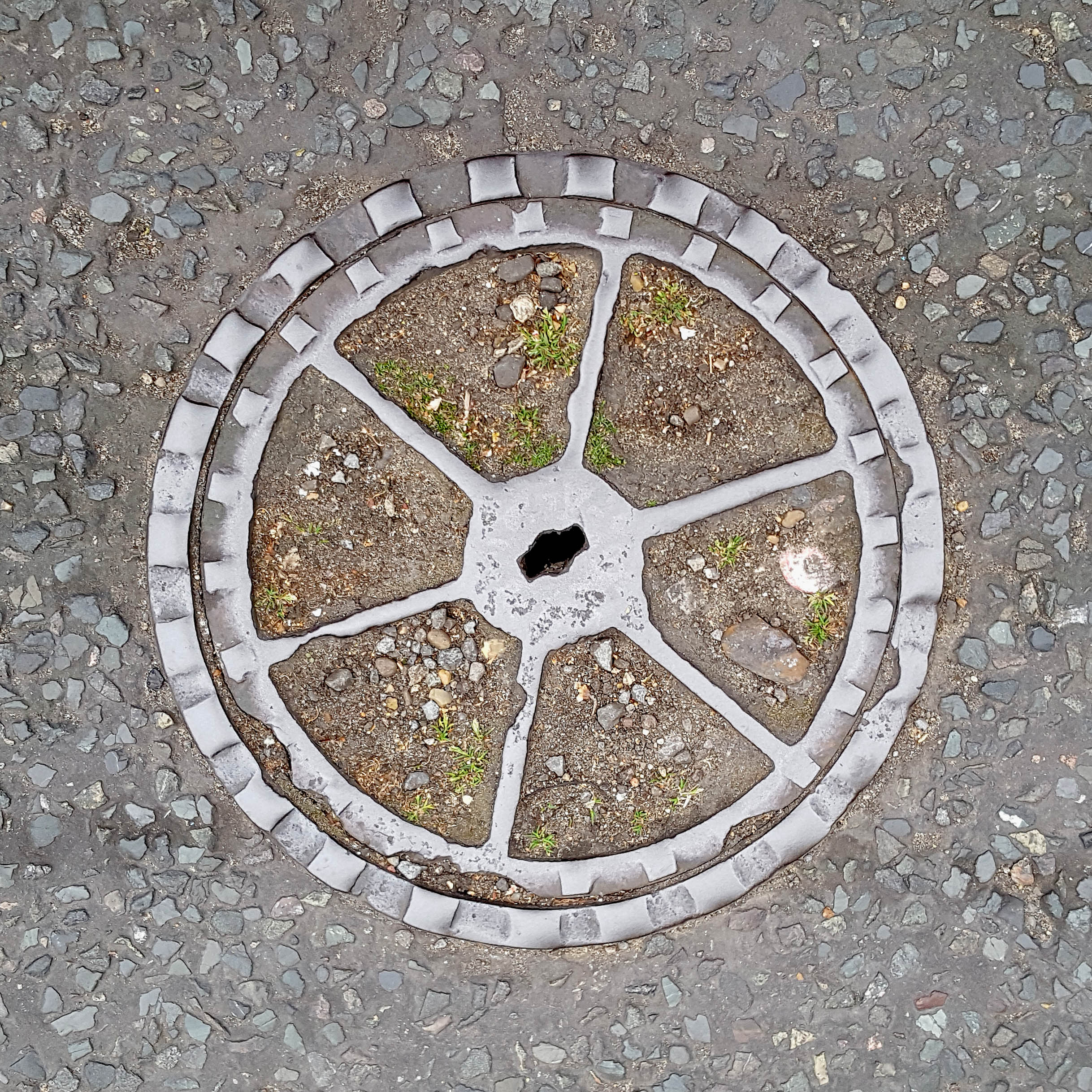 Manhole Cover, London - Cast iron surround with dirt centre divided into six segments