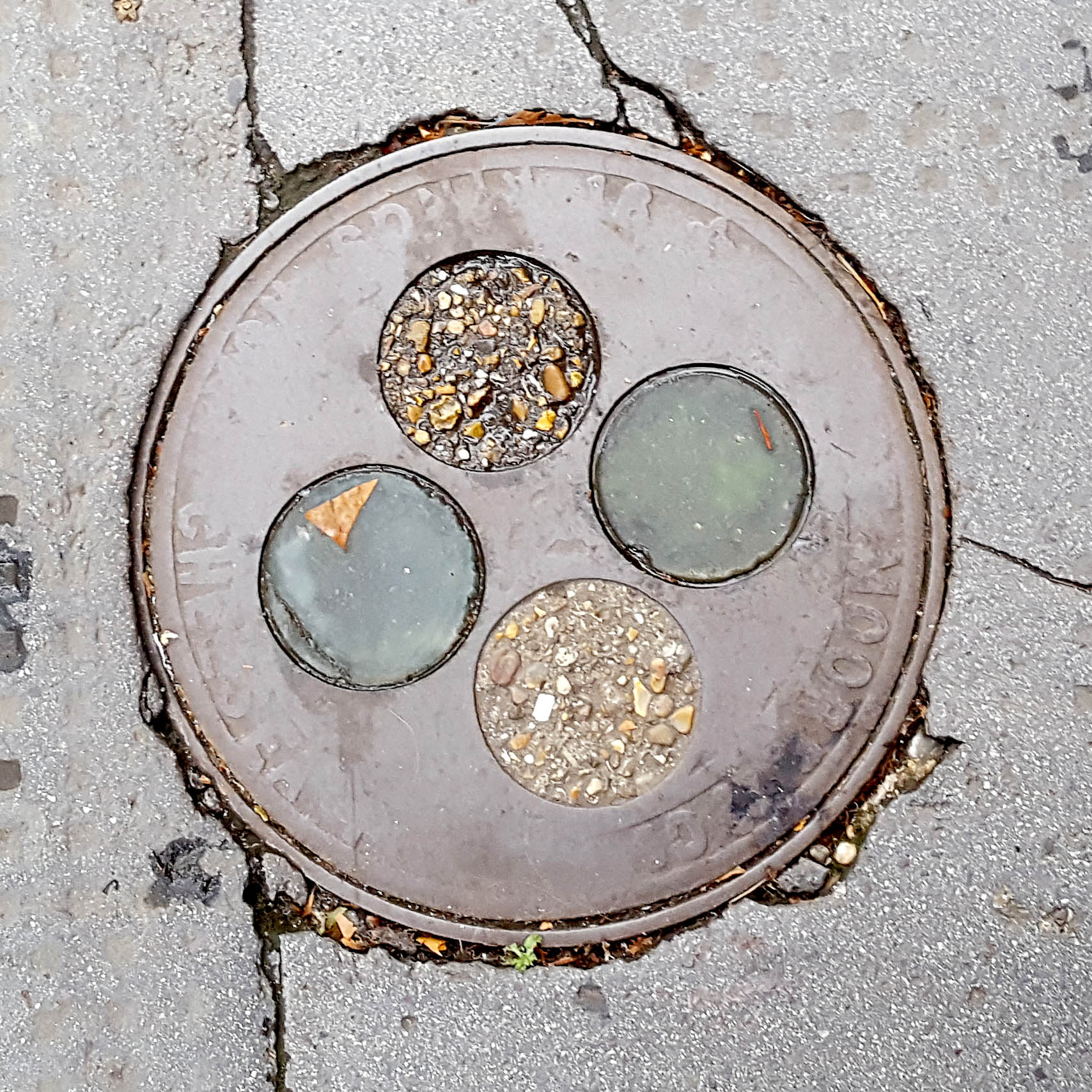 Manhole Cover, London - Cast iron with four circles of concrete and glass