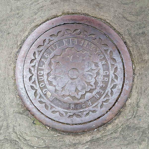 Manhole Cover, London - Cast iron with decorative circular fleur dis lis pattern -  Inscribed with R DOUGLAS 117 NEWINGTON GREEN RD London NE