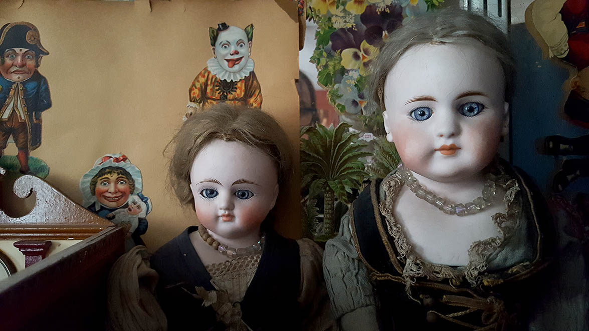 Two ceramic dolls in glass display case in Pollocks Toy Museum