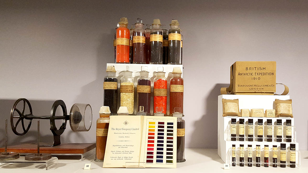 Assortment of glass jars filled with coloured powder and packages for the British Antartic Expedition of 1910 displayed in glass cabinets in The Science Museum