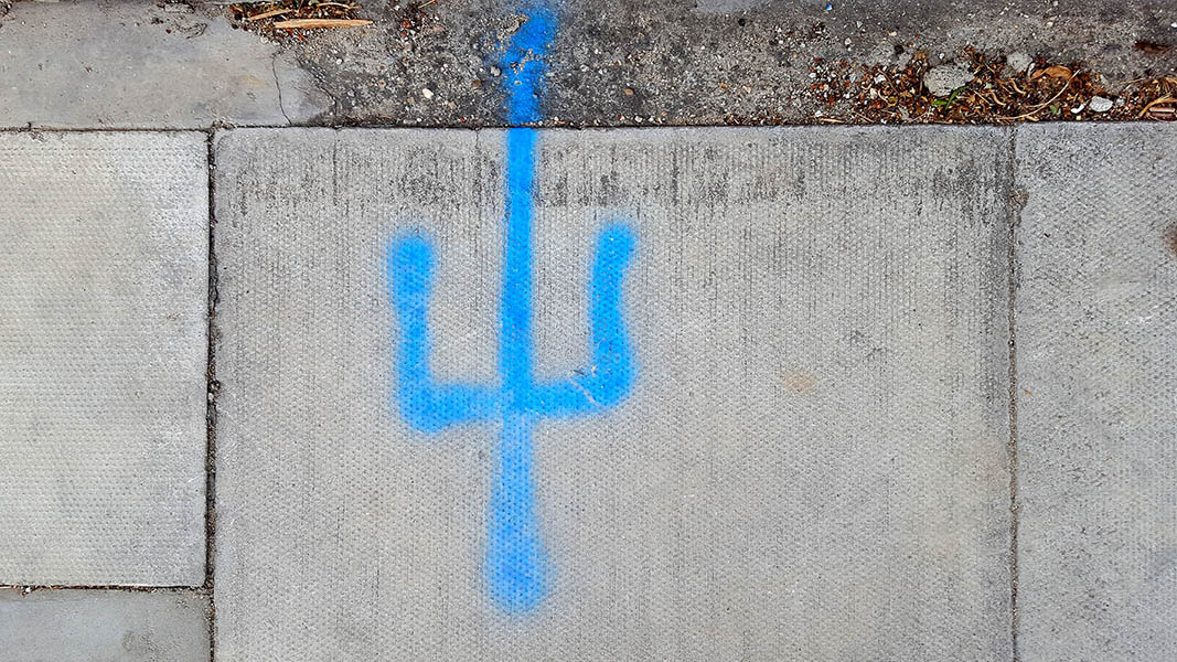 Pavement markings - spray painted squiggles on paving stones - Blue vertical lines