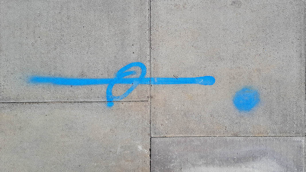 Pavement markings - spray painted squiggles on paving stones - Blue horizontal line ellipse and dot