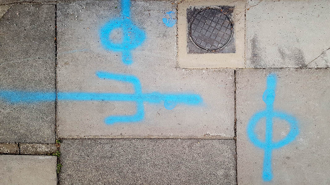 Pavement markings - spray painted squiggles on paving stones - Blue lines and circles
