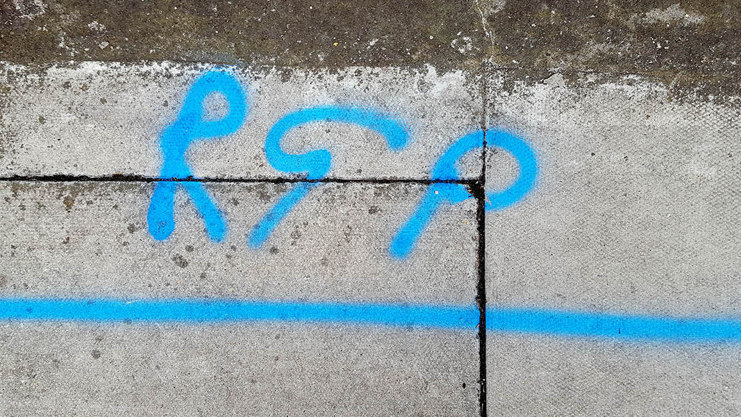 Pavement markings - spray painted squiggles on paving stones - Blue horizontal lines and the letters RGP