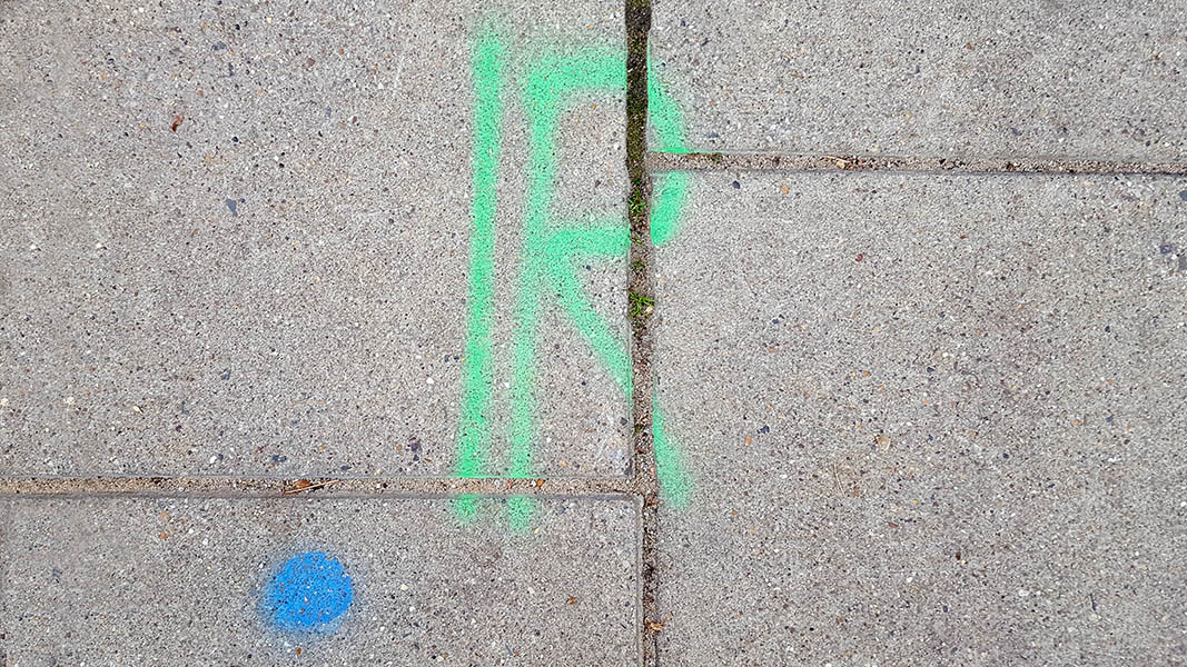 Pavement markings - spray painted squiggles on paving stones - Green R and blue dot