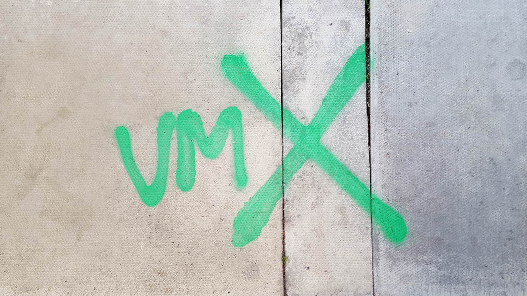Pavement markings - spray painted squiggles on paving stones - Green VM and big X