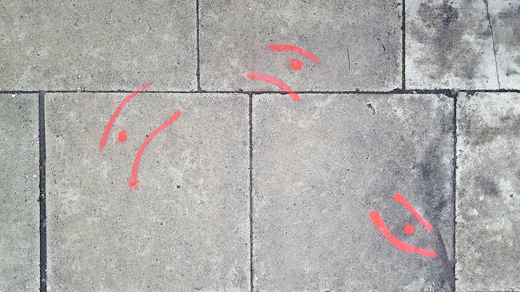 Pavement markings - spray painted squiggles on paving stones - Red curved lines and dots