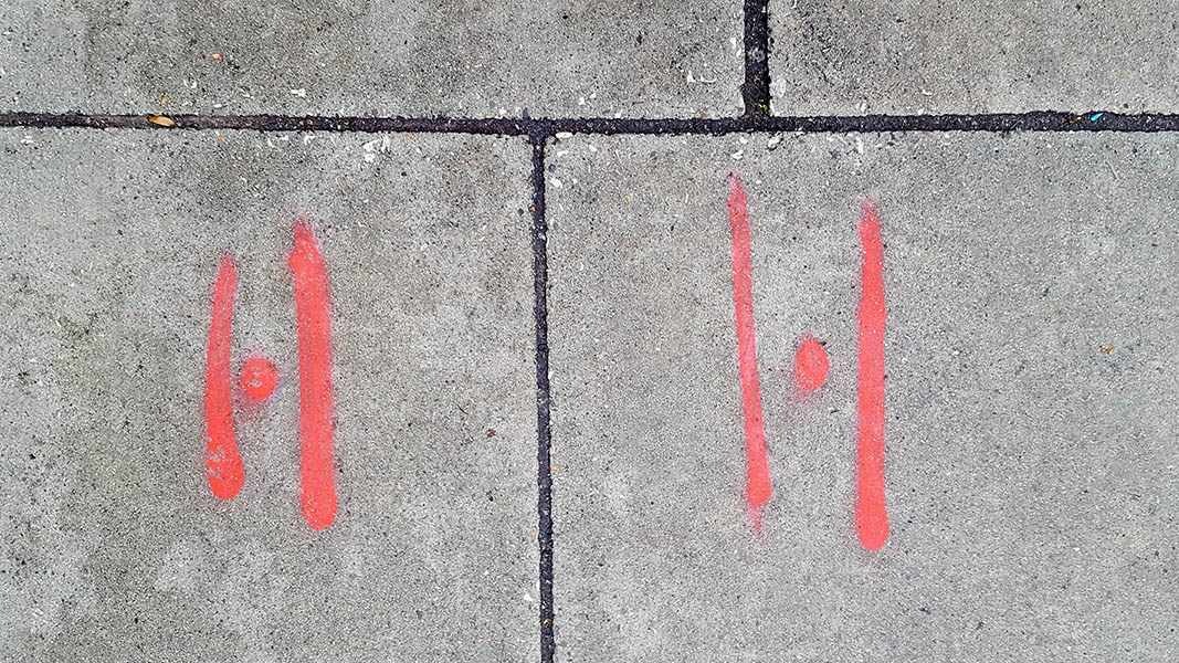 Pavement markings - spray painted squiggles on paving stones - Red vertical lines and dots