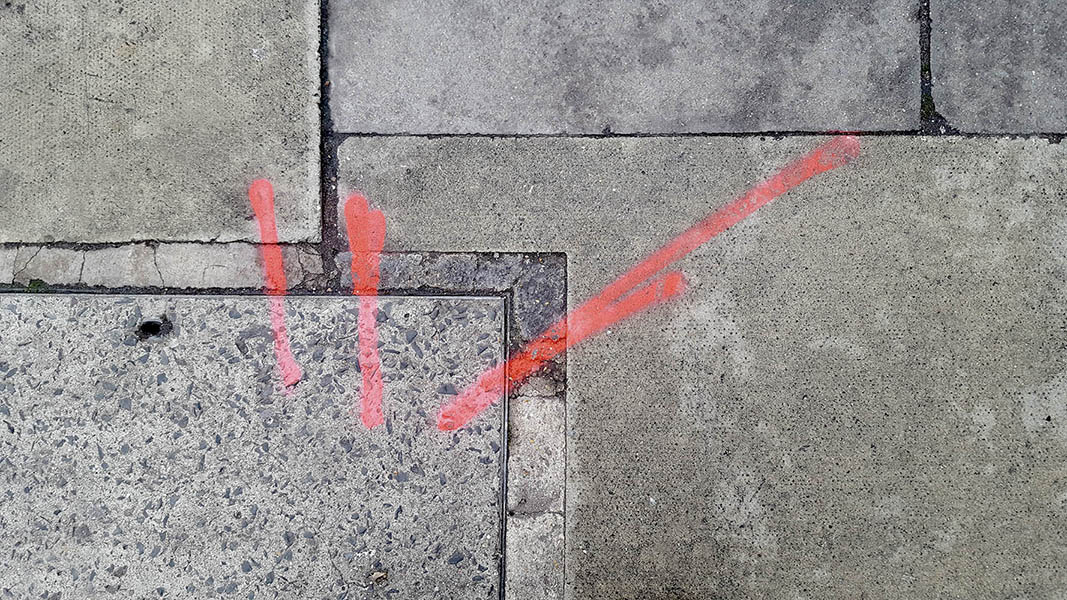 Pavement markings - spray painted squiggles on paving stones - Red lines