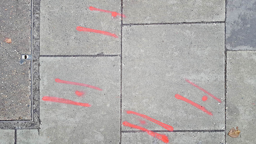 Pavement markings - spray painted squiggles on paving stones - Red lines and dots