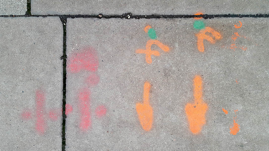 Pavement markings - spray painted squiggles on paving stones - Red and orange arrows and squiggles