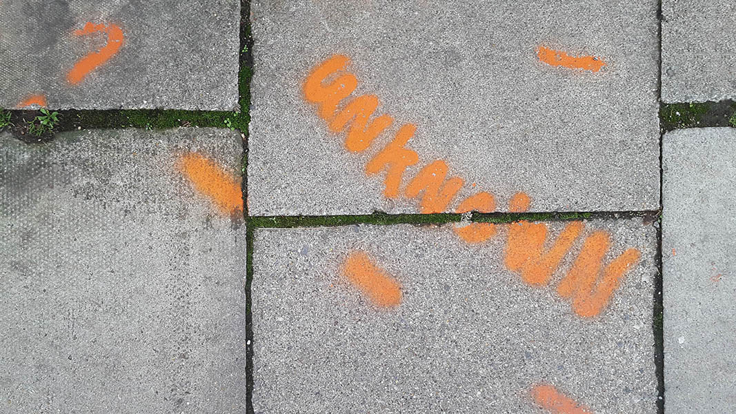 Pavement markings - spray painted squiggles on paving stones -  Orange UNKNOWN and dashed lines