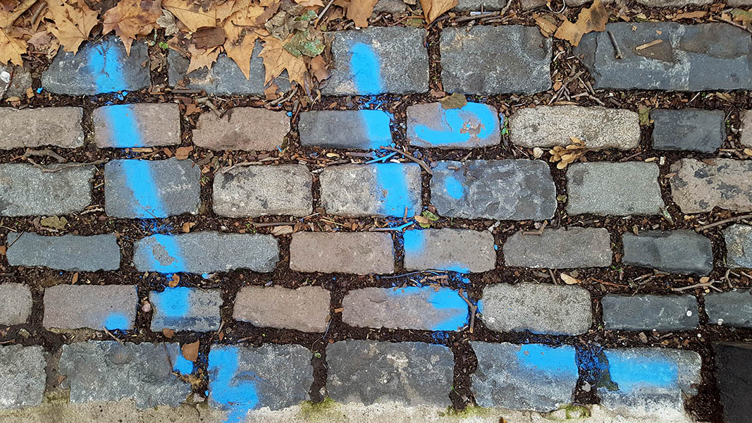 Pavement markings - spray painted squiggles on cobblestones - Blue lines