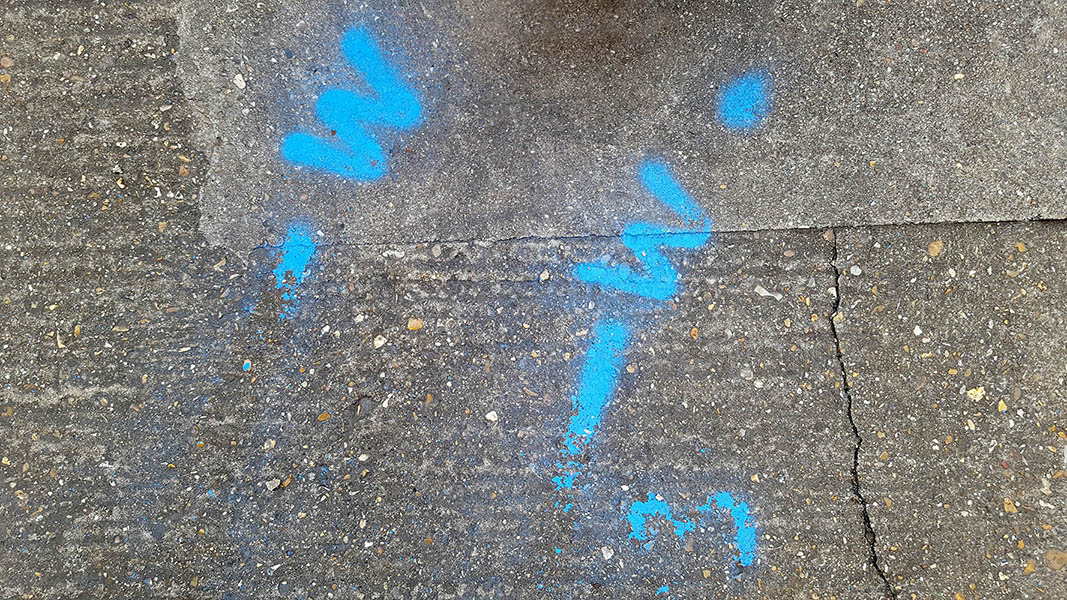 Pavement markings - spray painted squiggles on paving stones - Blue lines and W