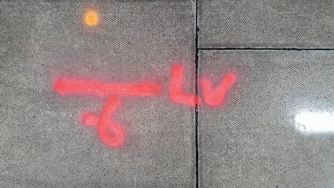 Pavement markings - spray painted squiggles on paving stones - Red orange white squiggles