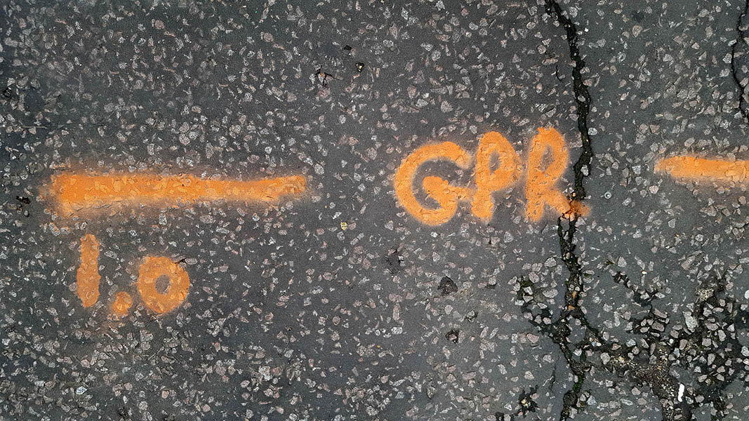 Pavement markings - spray painted squiggles on tarmac - Orange lines and letters