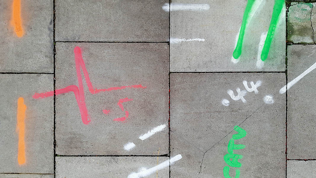 Pavement markings - spray painted squiggles on paving stones - Red orange white and green lines