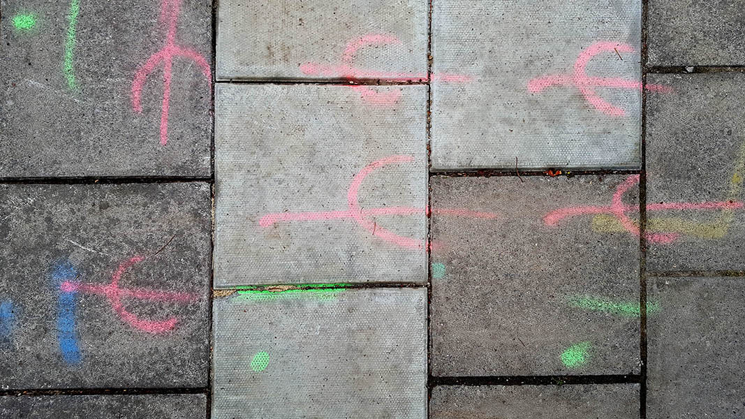 Pavement markings - spray painted squiggles on paving stones - Red green blue squiggles