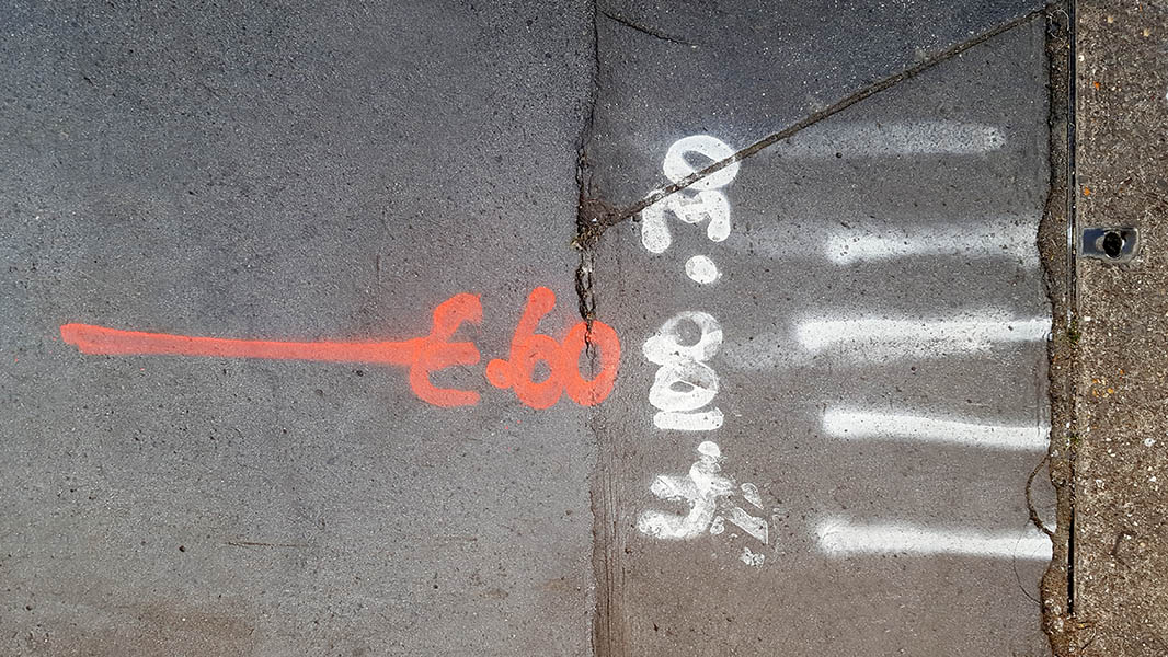 Pavement markings - spray painted squiggles on paving stones - Red and white letters and lines