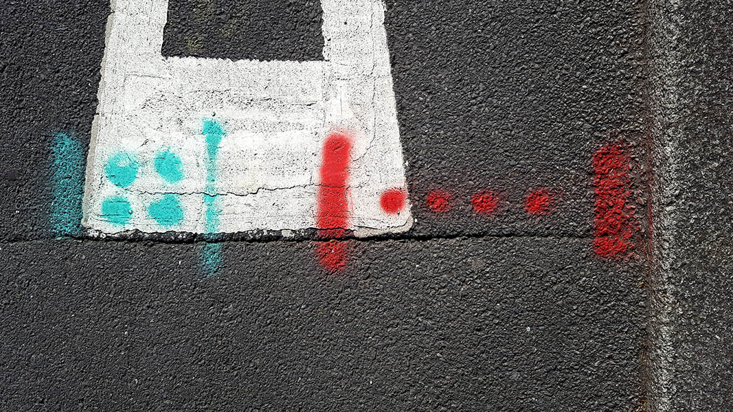 Pavement markings - spray painted squiggles on paving stones - Red and blue dots and lines