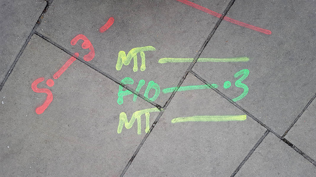 Pavement markings - spray painted squiggles on paving stones - Yellow green and red letters and lines