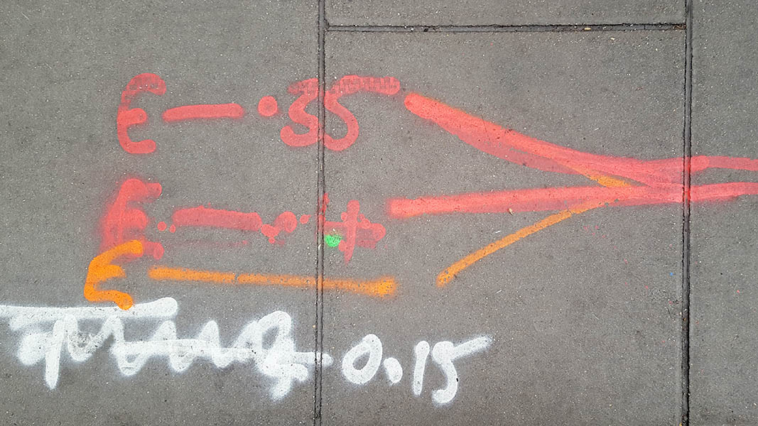 Pavement markings - spray painted squiggles on paving stones - White orange and red letters and lines