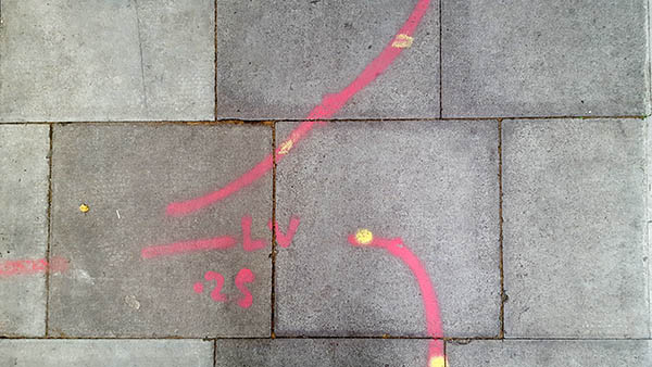 Pavement markings - spray painted squiggles on paving stones - Red curved lines