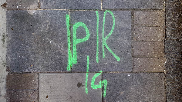 Pavement markings - spray painted squiggles on paving stones - Green letters P R ang G