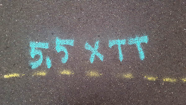 Pavement markings - spray painted squiggles on paving stones - Turquoise 5.5 x T T and a dashed yellow line
