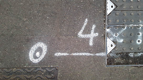 Pavement markings - spray painted squiggles on paving stones - White number 4 and markings