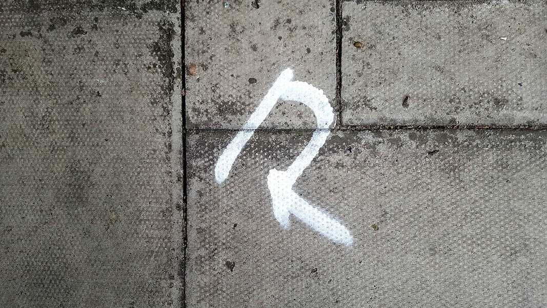 Pavement markings - spray painted squiggles on paving stones - White squiggle