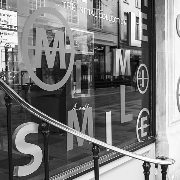 Window display of gold & copper letters spelling smile