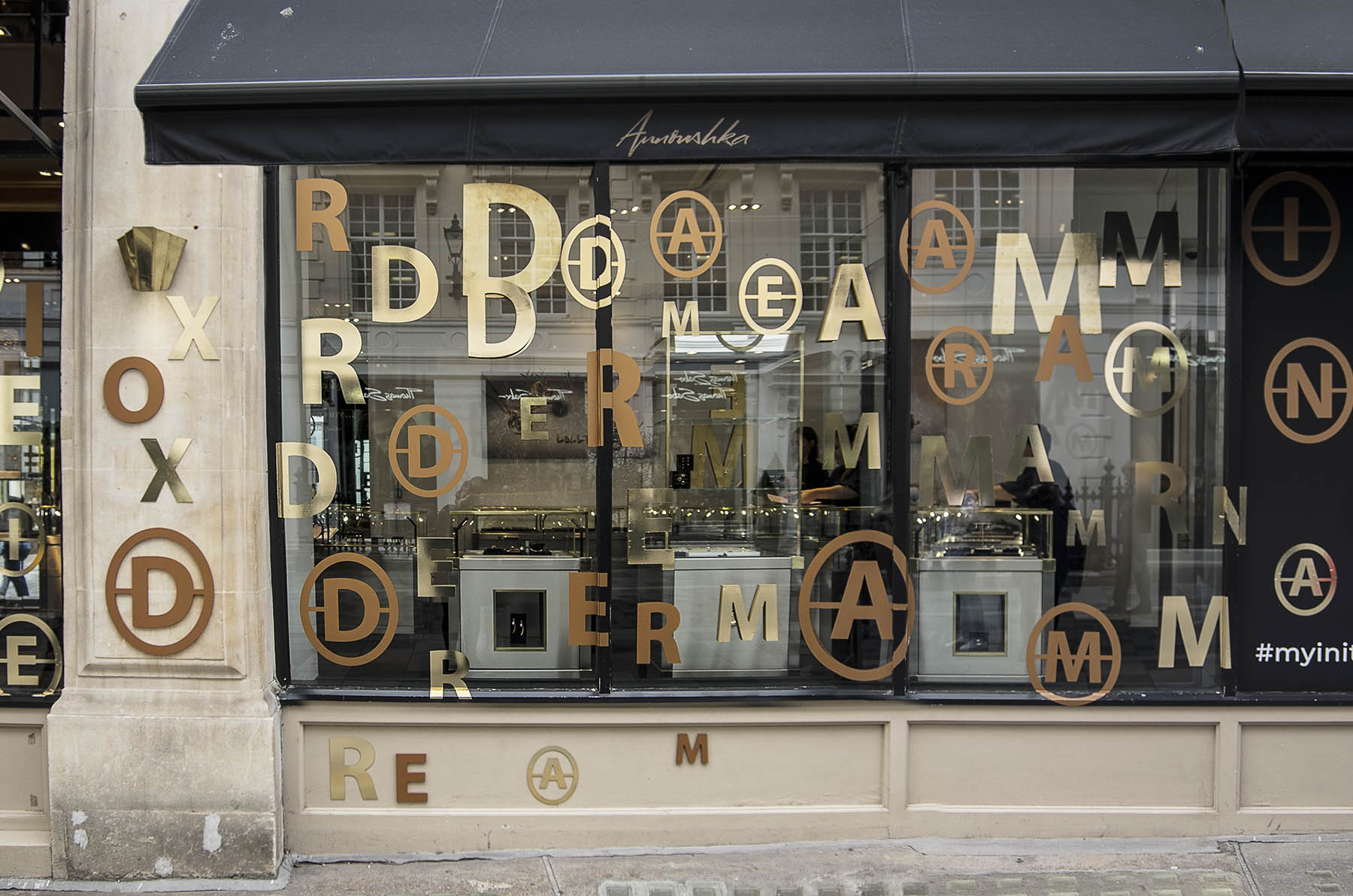 Annoushka Initials window display - gold and copper letters spelling Dream