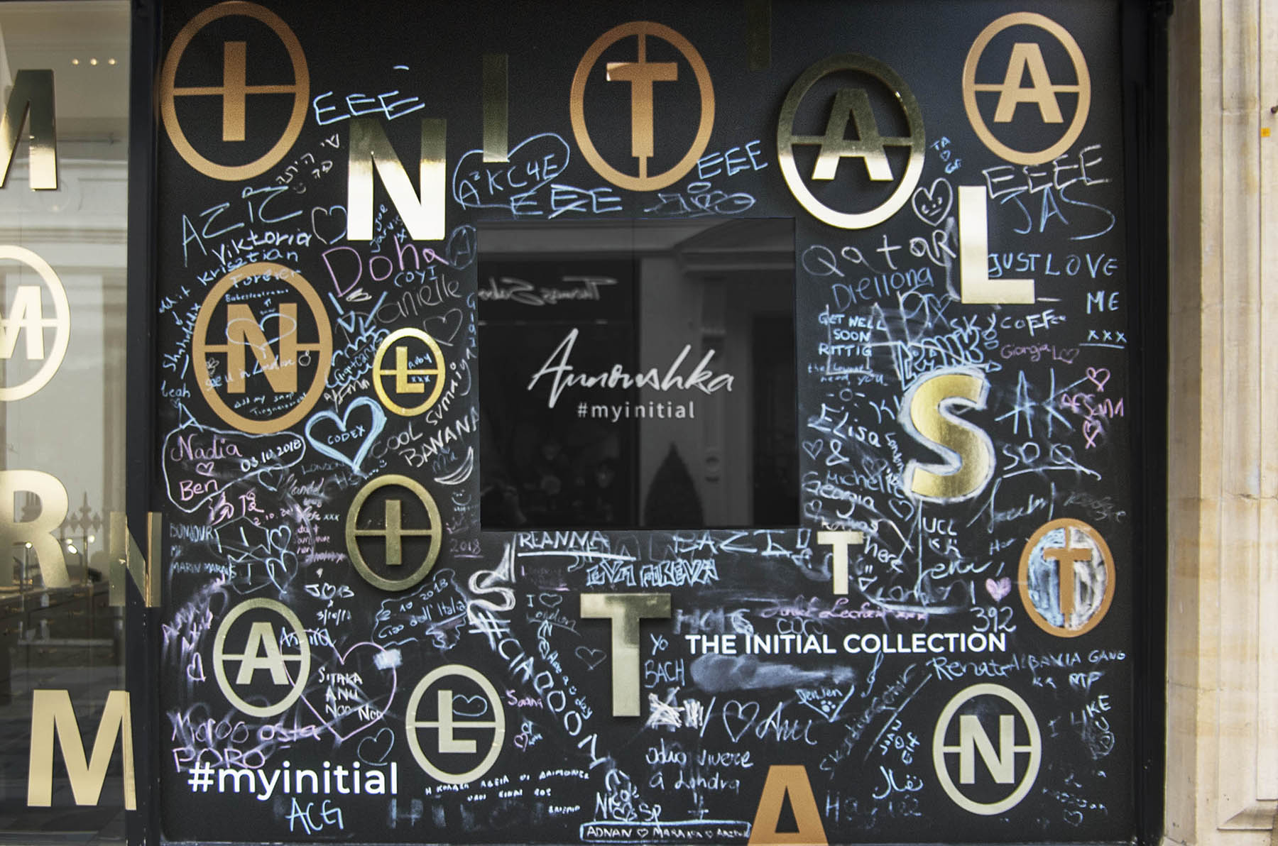 Annoushka Initials window display - chalkboard with writing and gold and copper letters spelling Initials