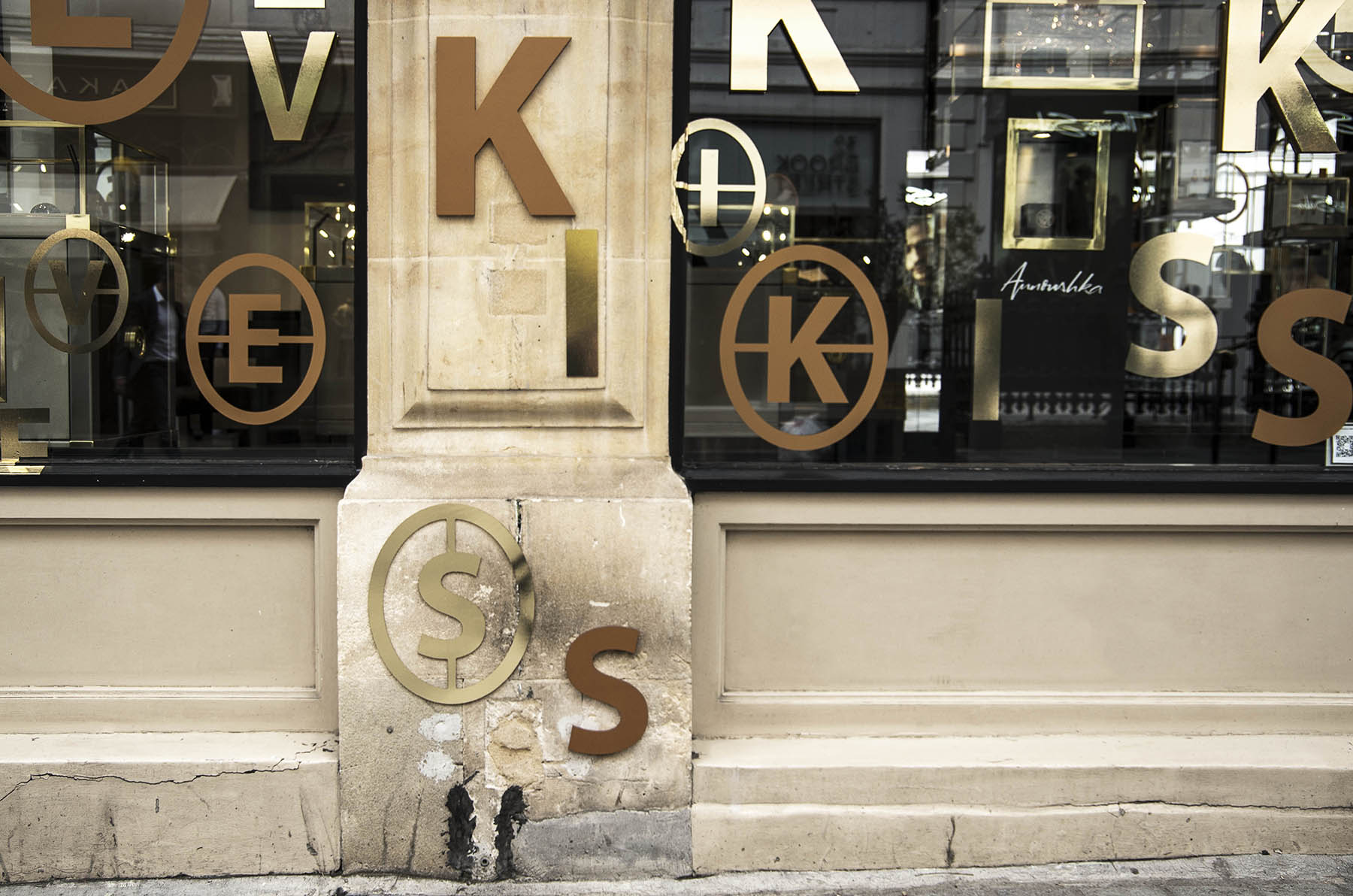 Annoushka Initials window display - gold and copper letters spelling Kiss on wall and windows 